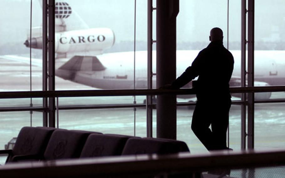 A security worker gazes out a large glass overlook to the flight line as a cargo plane taxis in on a relatively slow Christmas day at the Ramstein passenger terminal. A handful of wounded servicemembers and space-available travelers made their way through the 723rd Air Mobility Squadron’s aero medical facility and passenger terminal during the holiday.