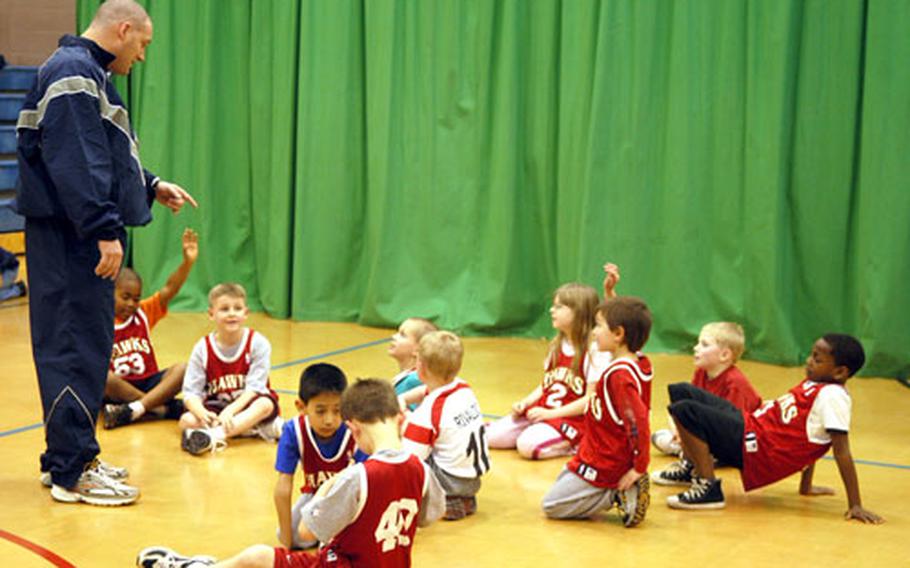 Bryant Martin, the Hawks head coach, talks to his players at the end of a practice last week at RAF Mildenhall's youth center.