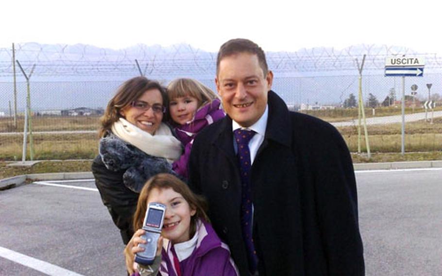 Leighlora, bottom left, and Lillian Ann stand near the entrance to Aviano Air Base, Italy, with Italian lawyers Esmeralda Di Risio and Francesco Furlan shortly after they were released back into the care of their mother on Saturday. Italian authorities had placed the children in Italian foster care and charged Staff Sgt. Kris Wylie with abandoning them while she was deployed. Charges against Wylie have been dropped. Di Risio and Furlan represented Wylie and her Italian fiance in court.