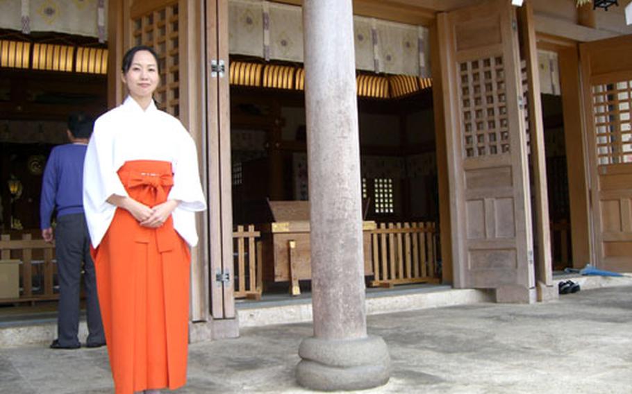 Yuka Tatetsu, one of the six Mikos, or shrine attendants, at Futenma Shrine in Ginowan near Camp Foster, waits to greet visitors during the hectic New Year's week. Okinawa police warn people to be careful on the highways during the week, when traffic becomes congested with thousands visiting area shrines.