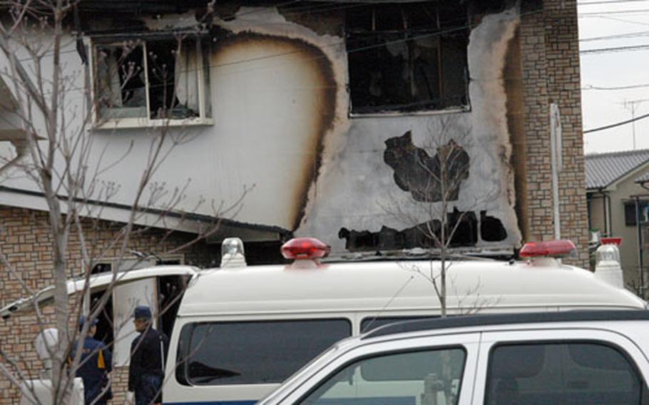 Japanese authorities investigate the charred remains of a two-story unit at the Bel Air Plaza housing complex in Hamura, which borders Yokota Air Base. A U.S. civilian who worked for the 374th Services Division was killed in the fire, which broke out early Saturday.
