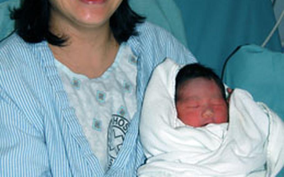 Seon-Ok Rah holds her new son William several hours after giving birth on New Year’s Day. Born at 12:38 a.m. at the 121st Combat Support Hospital Tuesday, William, 7 pounds, 5 ounces was the first member of the USFK community born this year.