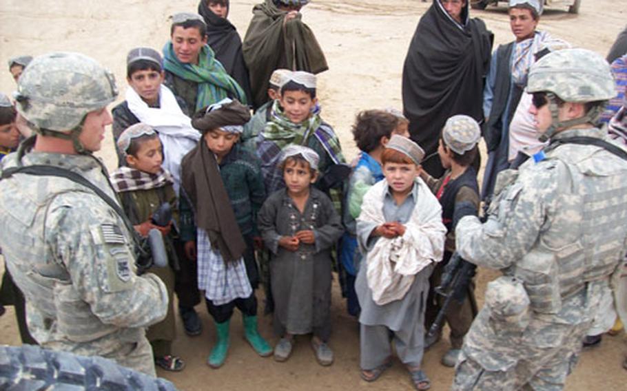 Soldiers from 1st Platoon, Company A, 1st Battalion, 4th Infantry Regiment hand out food, clothing and other items in Mizan District, Afghanistan on Dec. 20.