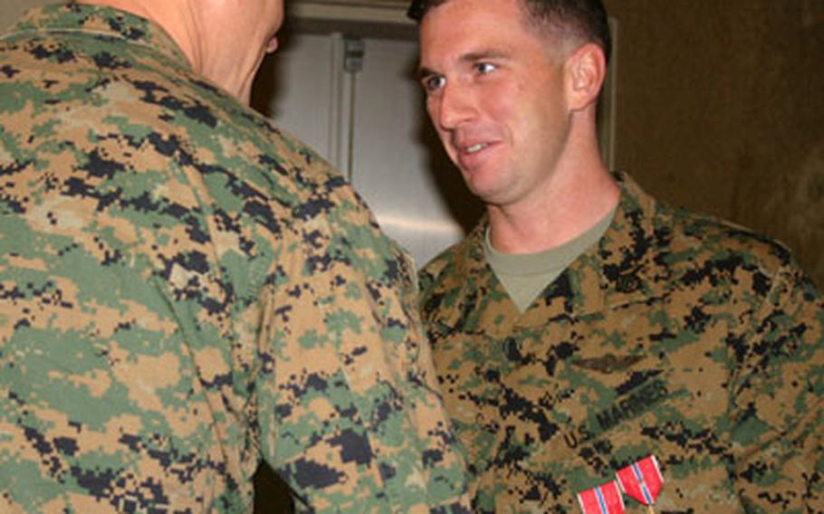 Marines congratulate Staff Sgt. Jacob B. Jones, right, an aviation operations specialist based at Marine Corps Air Station Futenma, on Wednesday after he received two Bronze Stars, one with Combat V, for a 2007 deployment to Iraq.