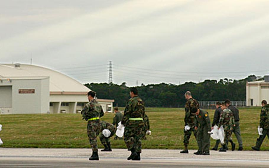 About 500 servicemembers walk along the two runways on Kadena Air Base looking for debris during the annual FOD Walk on Thursday.