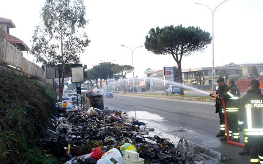 Firefighters in Lago Patria extinguish one of many trash fires burning across the city.