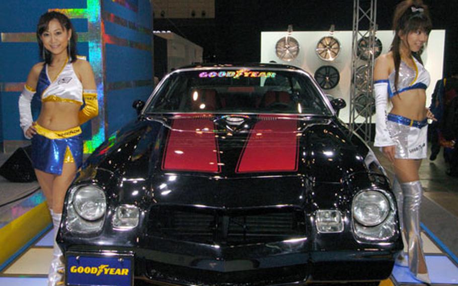 A customized 1980 Chevrolet Camaro is flanked by Japanese models at Tokyo Auto Salon 2008 on Friday.