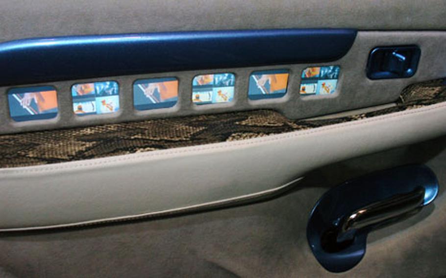 A Cadillac Escalade at Tokyo Auto Salon 2008 features tiny monitors along the armrest of a door. Some 78 monitors adorned the inside of the customized car.