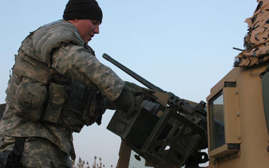 Sgt. Sidney Baker, 32, of New Castle, Del., loads ammunition into his Humvee's 50-calibre machine gun Saturday at Camp Victory, Iraq, while preparing for a mission to Forward Operating Base St. Michael. Baker, a member of the Delaware National Guard, serves as a gunner for the 153rd Military Police Company, 720th Military Police Batallion, 18th Military Police Brigade.