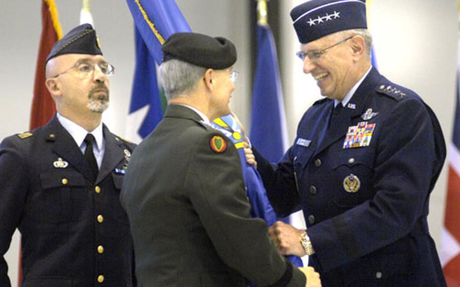 Gen. Roger Brady, new commander of U.S. Air Forces in Europe, accepts the NATO Allied Air Component Command flag from Gen. John Craddock, supreme allied commander Europe, during a ceremony Thursday. Italian Air Force Warrant Officer 1st Class Oscar De Mauro, left, command sergeant major for NATO, carried the NATO flag during the ceremony.