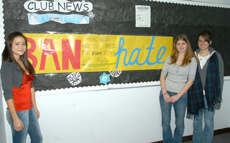 Emely Vallee, left, Samantha Cannon, center, and Stephanie Wehrung stand in front of a Gay-Straight Alliance banner in the hallway of Robert D. Edgren High School at Misawa Air Base, Japan. The new club at Edgren was formed to promote tolerance and awareness of others' differences.