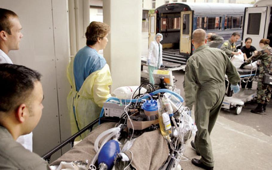Army Capt. Karla Clarke, center, an ICU nurse at Landstuhl Regional Medical Center, assists in transporting her patient to a bus for air transport Aug. 21st, 2007. LRMC has become the only hospital outside the U.S. designated as a Level II trauma center. With the new designation come tougher standards in everything from tracking patients to receiving patients and documenting medical care.