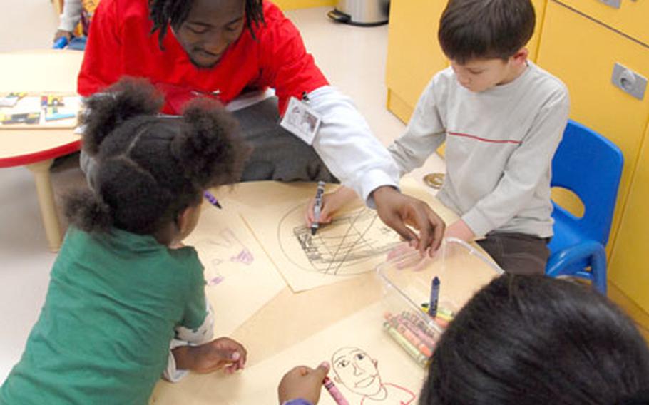 Jamaal Mohn, a School Age Services employee, plays with children at a new child care center inside the 1st Replacement Company building on Yongsan Garrison, where servicemembers go for in-processing when they arrive in South Korea. Parents can drop their children off at the center during the two-day spouse orientation program.