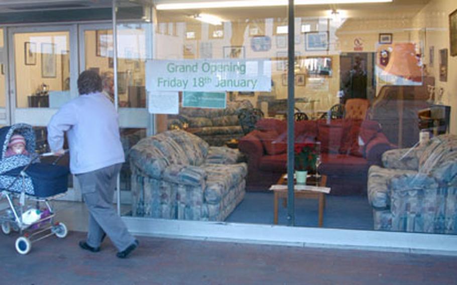 A woman walks past a new furniture shop in Mildenhall operated by the St. Nicholas Hospice. The shop hopes U.S. base personnel will volunteer and donate items that will raise money for the hospice.