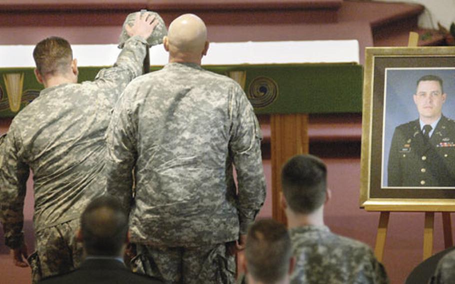 V Corps’ Command Sgt. Maj. Ralph Beam reaches out in remembrance of Maj. Michael Green at the conclusion of a memorial ceremony in his honor Tuesday at the Patrick Henry Village Chapel in Heidelberg, Germany. Green, a team leader for a Counter Improvised Explosive Device Team, died on Jan. 7th while serving as convoy commander with an explosive ordinance detachment in Afghanistan.