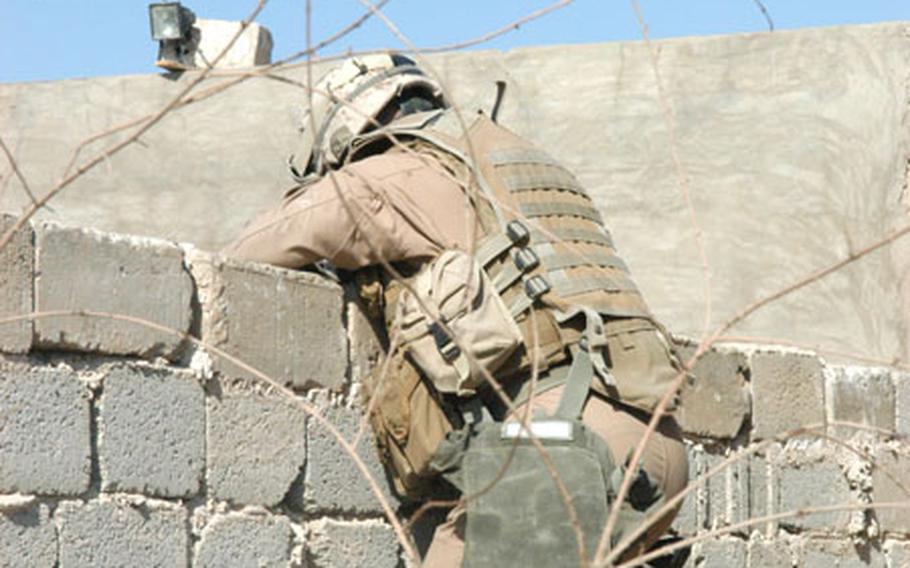 A gear-laden Marine tries to get over a wall in Karmah, Iraq, earlier this month. A decision on whether to allow Marines to ditch their helmets and other gear while on patrol in Anbar will be taken up by the incoming command of I Marine Expeditionary Force. The idea was first pitched earlier this year in light of improving security in the province.