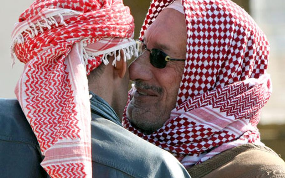 A Shiite tribal sheik from Little Barwana, right, kisses his Sunni counterpart from Big Barwana on the cheek after a peace deal was signed Thursday between the two villages. The deal ended two years of bloodshed between the two villages and was brokered by troops of 3rd Squadron, 2nd Stryker Cavalry Regiment.
