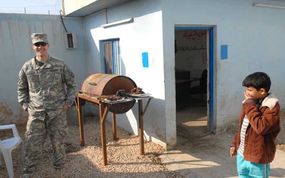 Army Pfc. Roy Muffler, 21, of St. Louis, guards the afternoon's grilled treats. Company D, 2d Battaltion, 502d Infantry Regiment, 101st Airborne Division, based at Fort Campbell, Ky., has managed to carve out a relatively pleasant existence since they arrived at their Haswah, Iraq, patrol base in October.