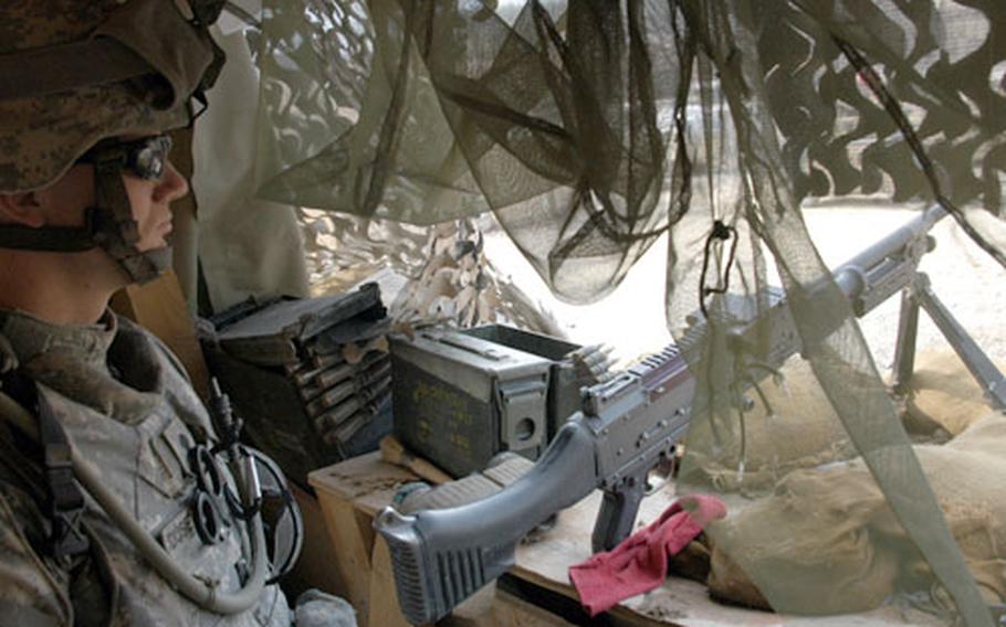 Spc. James Dusenbery, 22, of Spokane, Wash., watches over his observation point on the roof of the Joint Security Station in Yusufiyah, Iraq. Forty soldiers from 3rd Platoon, 65th Military Police Company (Airborne), 720th Military Police Battalion, 18th Military Police Brigade are assigned full time to the outpost.