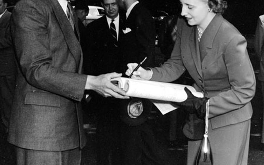 Margaret Truman signs a guest book during her visit to Luxembourg in June, 1951.