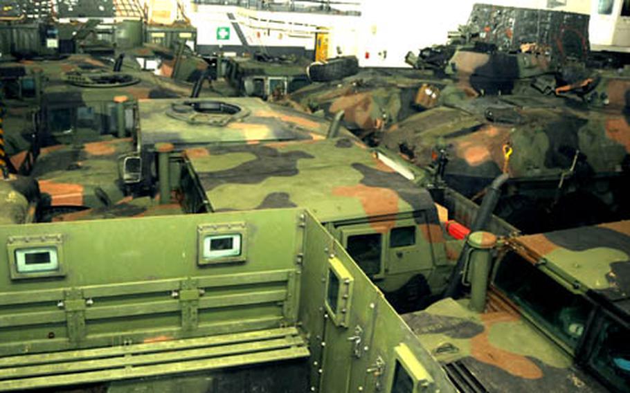 Vehicles are packed as tightly as possible into a storage space aboard the USS Essex, which is off Okinawa&#39;s shore.