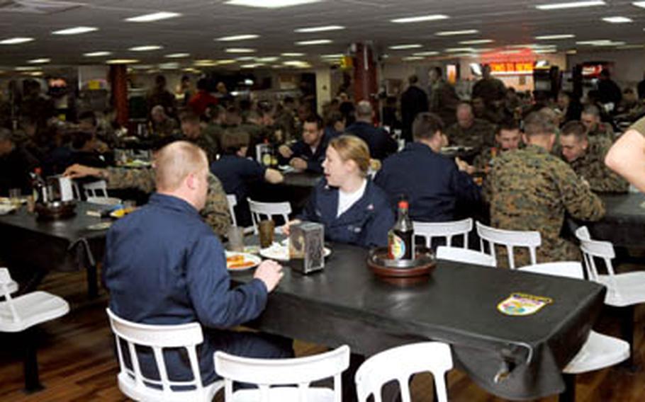 Essex sailors and 31st Marine Expeditionary Unit crowd the enlisted galley aboard the Essex during lunch Tuesday.