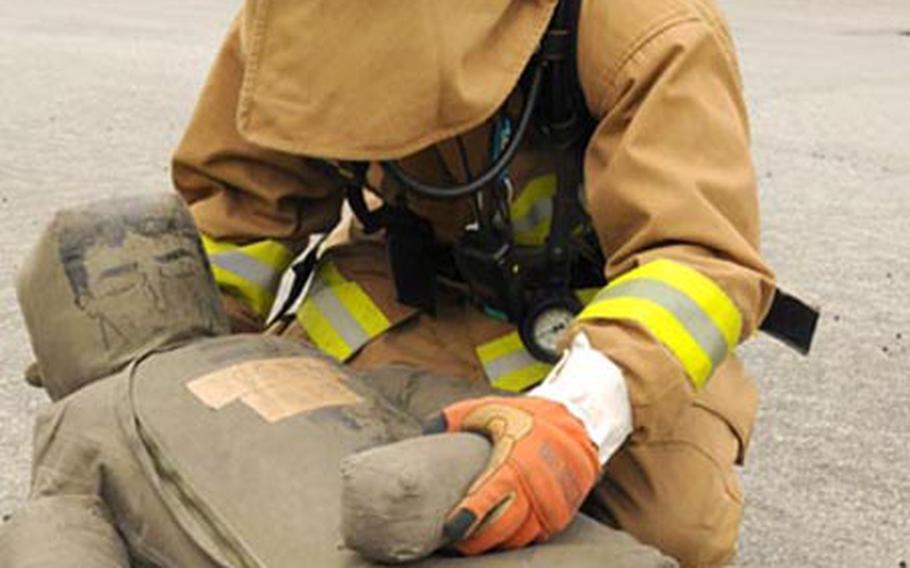 A firefighter with the Nirai, Okinawa, Fire Department rescues a "victim" during a joint hazerdous-material training exercise with the Kadena Air Base Fire Department at the base&#39;s fire pit Thursday.