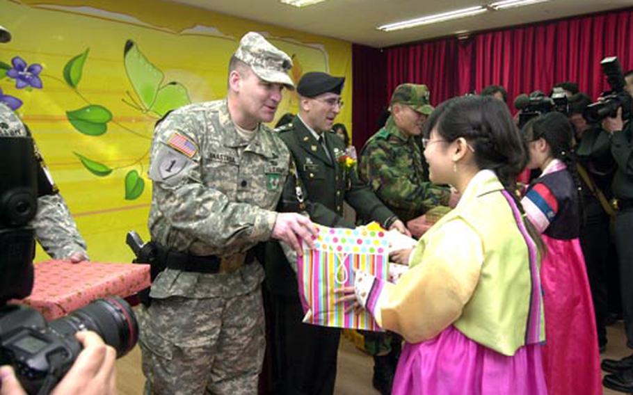 U.S. Army Lt. Col. Michael Anastasia, commander of the United Nations Command Joint Security Area Security Battalion, hands a graduation gift to 12-year-old Jun Eun-young on Friday after the student graduated from the sixth grade at Tae Sung Dong village in the demilitarized zone.