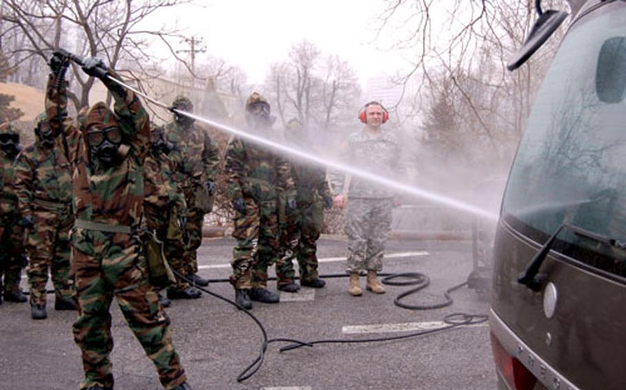 David Kim, U.S. Army Corps of Engineers, Far East District, uses a Multi Purpose Decontamination System to spray a van during Chemical, Biological, Radiological and Nuclear defense training Monday at U.S. Army Garrison, Yongsan.