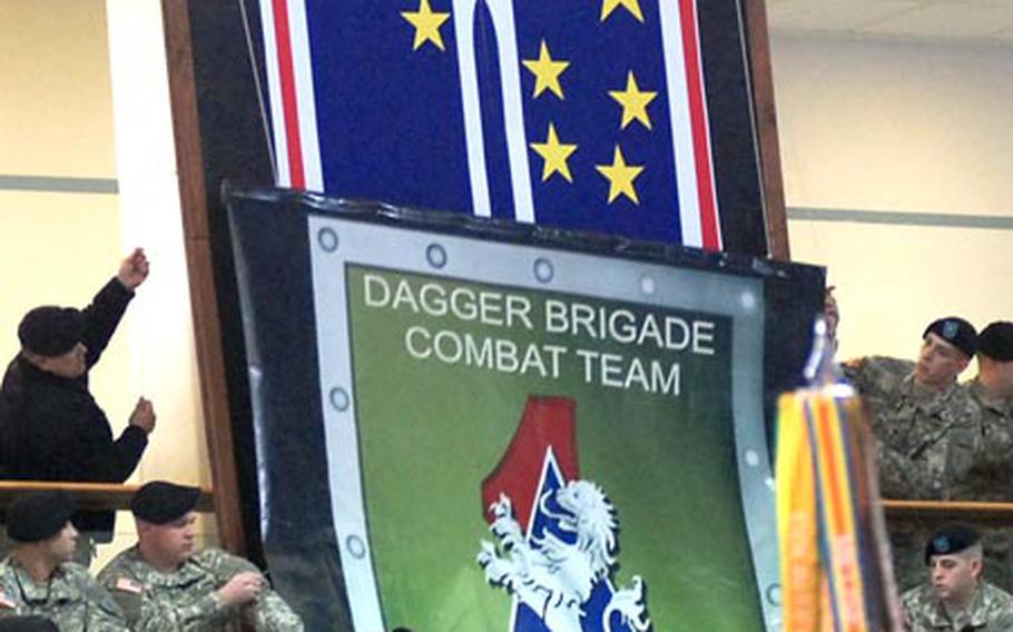 The insignia of the 2nd Brigade Combat Team, 1st Infantry Division comes down, revealing the insignia of the newly reactivated 172nd Infantry Brigade, as soldiers switch patches at a ceremony in Schweinfurt, Germany, on Monday.