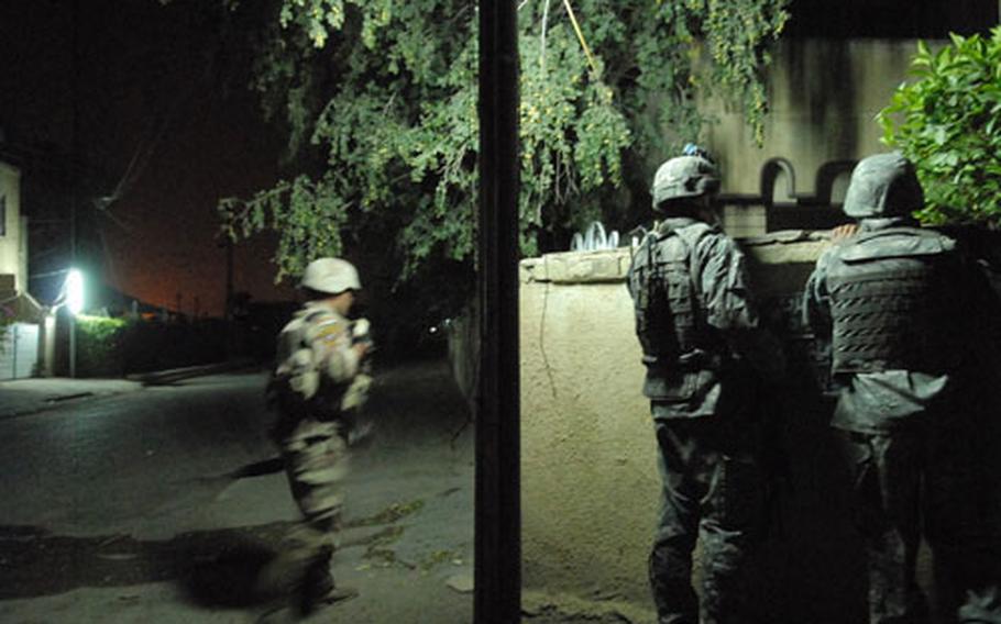 An American soldier peeks over a wall