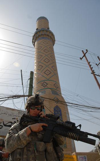 A soldier checks in on the radio during a patrol
