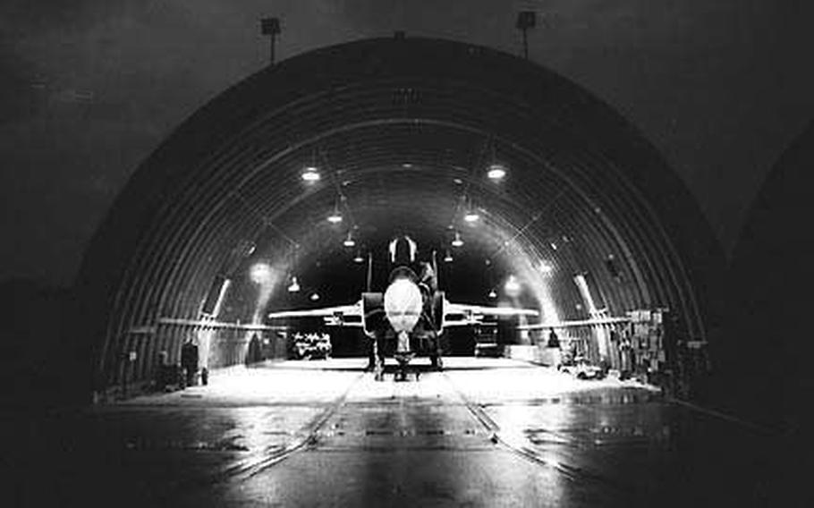 Staff Sgt. Edwin L. May and Airman Linnon Lathan work on an F-15 in the hangar at Bitburg Air Base, Germany, in November, 1979.