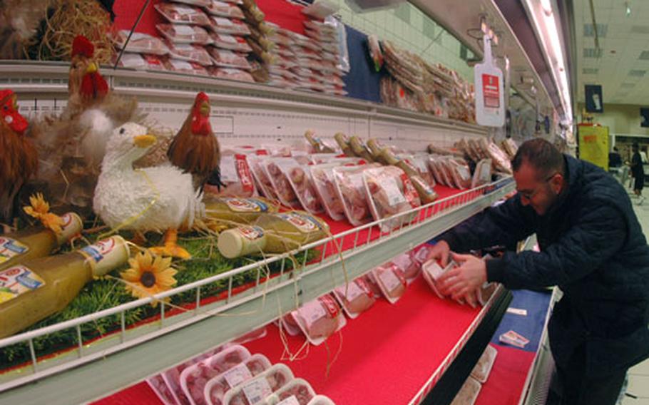 Nino D’Aloi adjusts fresh chicken packages in the commissary at the support site base in Naples, Italy, after a delivery Tuesday. Delivery of fresh chicken was suspended in February after inspection of the processing plant found coliform bacteria in water used to clean chickens after they are gutted.