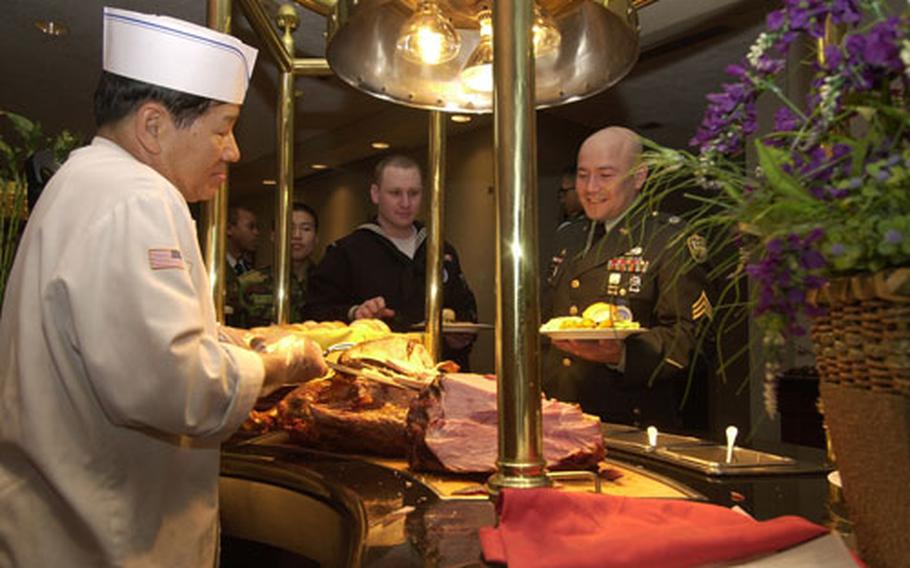 U.S. Army Sgt. Cesar Alvarado, who serves with the United Nations Command’s Military Armistice Commission, waits for a serving of turkey during the USO’s 37th annual “Six Star Salute” on Thursday at Yongsan Garrison, South Korea. Alvarado was one of 80 troops from across the peninsula selected for the two-day program.