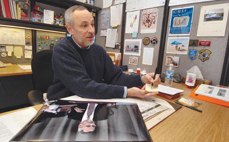 enw# 129p bs Alan Dooley/Courtesy to Stripes In an interview, Archaeologist Michael “Sonny” Trimble draws a diagram to show where he was in a courtroom, in relation to Saddam Hussein and "Chemical Ali." In the foreground tis a photo of him testifying.