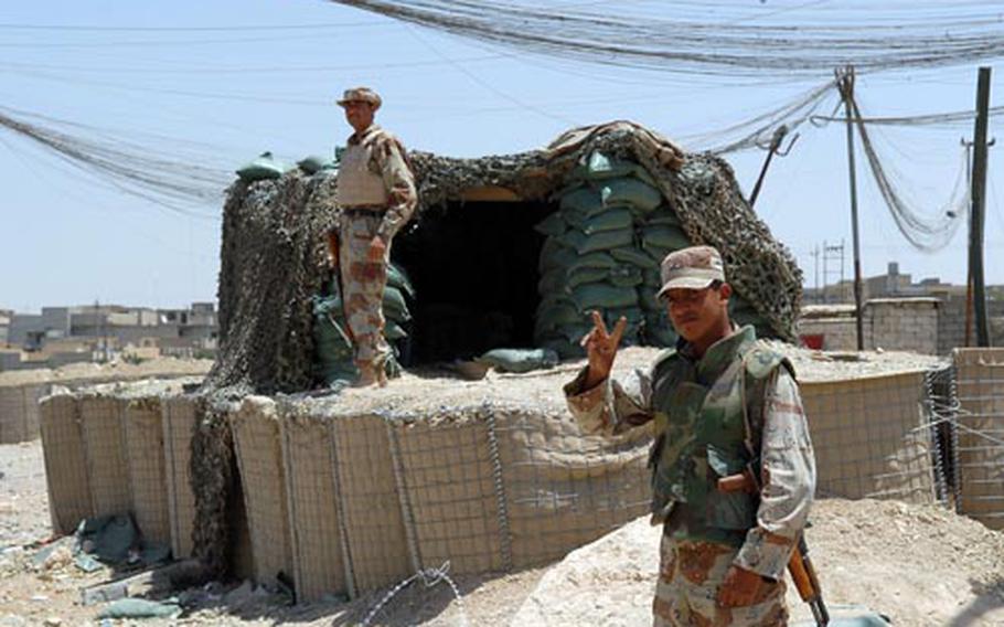 An Iraqi Army soldier at one of Mosul’s many checkpoints gives the peace sign Sunday to passing American soldiers. In some other areas, the checkpoint might be manned by members of "Sons of Iraq."