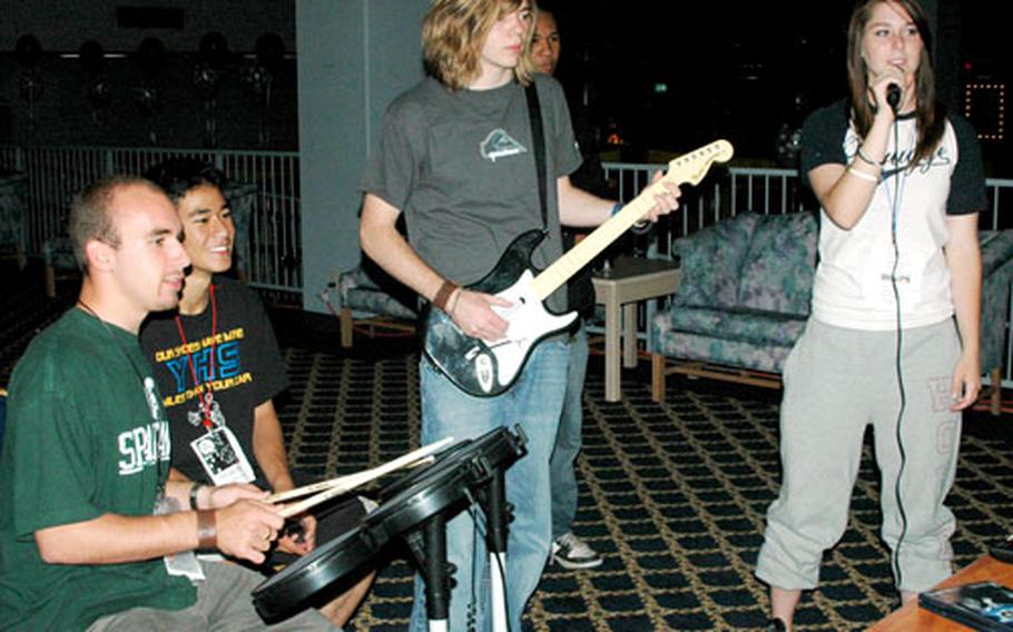 Yokota High School graduates play the video game "Rock Band" during the Project Graduation party Wednesday night at Taiyo Community Center on Yokota Air Base, Japan.