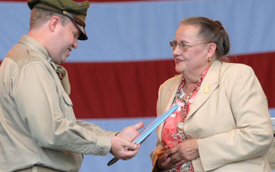 Mercedes Wild presents a copy of the book "Mercedes and the Chocolate Pilot" to U.S. Army Garrison commander Col. Ray Graham at the Berlin Airlift Open House on Sunday. As a little girl living in Berlin, Wild wrote "Candy Bomber" Gail Halvorsen a letter asking him to drop candy on her house. Halvorsen wrote a letter instead, the begining of a lifelong friendship.