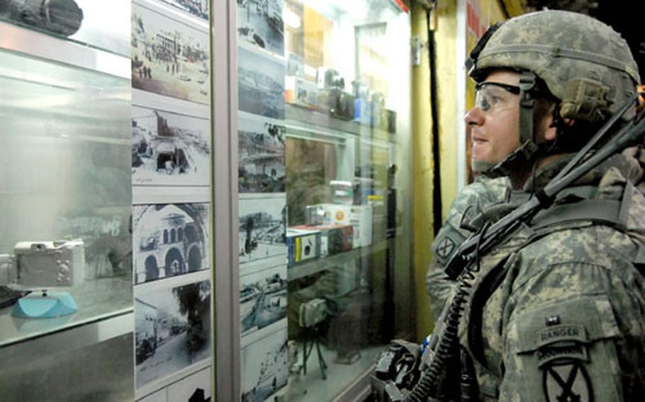 Capt. Doug Serie, commander of Headquarters and Headquarters Company, 2nd Battalion, 22nd Infantry Regiment, looks at old pictures of Kirkuk on Saturday in a camera store carrying everything from ancient film cameras to the latest digital cameras. Shops carrying high-end electronics have sprouted in the city's markets as security has increased.