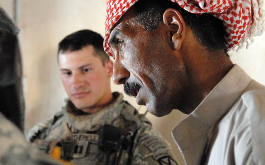 Taha Abdullah Hassin speaks through an interpreter Thursday to Capt. Blake Witherell (in background), commander of Company C, 2nd Battalion, 22nd Infantry Regiment, about the assassination of a sheik in his village two days earlier. The murdered man was the second such sheik assassinated in the area, which may suggest insurgents are reverting to more desperate tactics as they are quickly losing ground in the area.