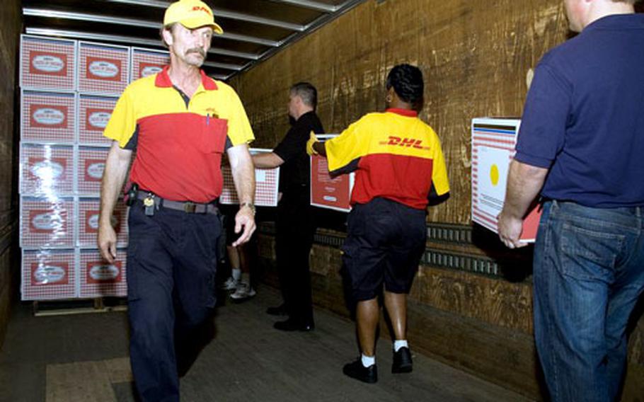 DHL drivers Danny Massengill, left, and Jade Robbins, center, load pizzas onto delivery trucks with help from employees from Lou Malnati's restaurant chain. The companies chipped in thousands in donations and services to help deliver 3,000 fresh pizzas to Iraq this week.