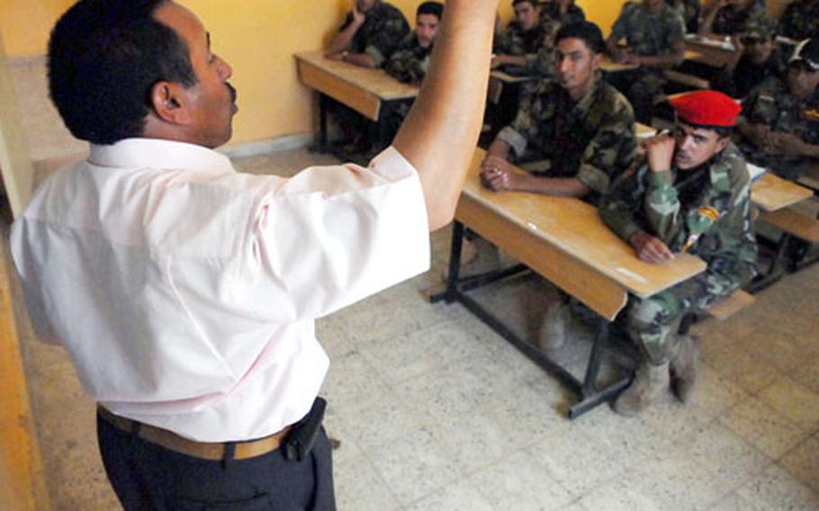 Hassen Ibrahim Mahmood teaches “Sons of Iraq” members to read and write Saturday in Hawijah, Iraq, as part of the National Literacy Pilot Program.
