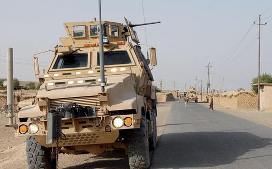 A Mine Resistant Ambush Protected vehicle guards a soccer field Thursday during a match between American soldiers and Iraqis in Sabagiya, Iraq. The oversized vehicle will soon share the road with local drivers.