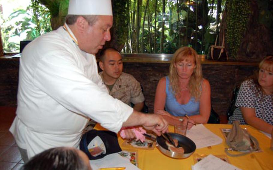 Chef Bruce Mattel of the Culinary Institute of America shows an audience of sailors and family members how to tell when chicken breasts are ready to turn over during a demonstration Wednesday at the Navy Club on Yongsan Garrison.