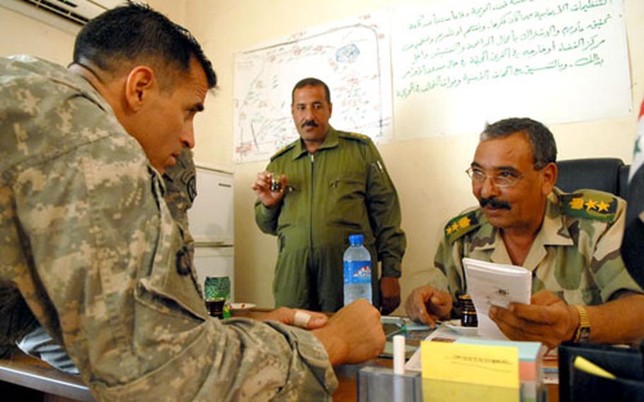 Lt. Col. Chris Vanek, commander of 1st Battalion, 87th Infantry, discusses intelligence on terrorist cells in Hawijah, Iraq, with Col. Khalaf Ibrahim Ali, a “Sons of Iraq” leader. The unit credits much of the security gains in the area to the "Sons of Iraq" program.