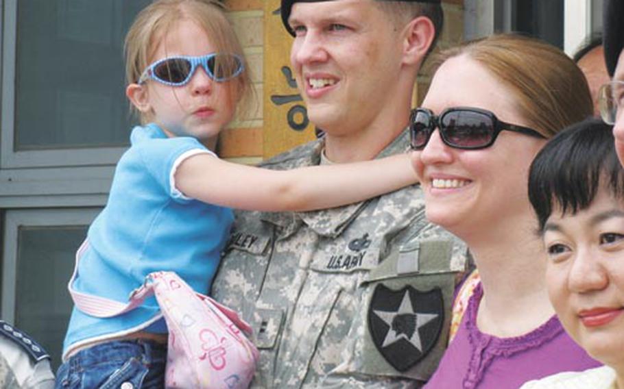 Krista Bailey, 5, hugs her father, Chief Warrant Officer 2 Michael Bailey, outside Ganeung police station in Uijeongbu on Thursday. Next to them are Krista's mother, Danialle Bailey, and Im Su-jung. Im found Krista Bailey alone on a Uijeongbu city bus and brought her to the police, who then notified the family.