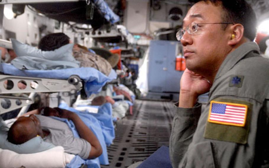 Air Force Lt. Col. (Dr.) Raymond Fang sits in a C-17 loaded with war wounded as it prepares to depart Ramstein Air Base, Germany, for Andrews Air Force Base in Maryland on June 29. Fang, a trauma surgeon at Landstuhl Regional Medical Center, is conducting a study on the feasibility of using the V.A.C. Freedom, a portable wound vacuum system, on medical evacuation flights between Germany and the U.S.