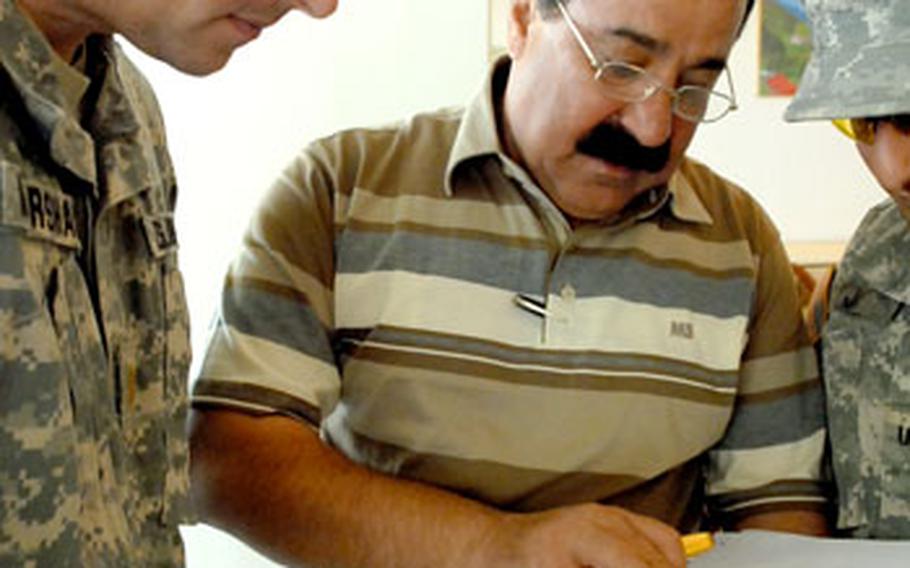 Abozaid Samad Sharif, right, shows plans for upcoming Civil Service Corps projects in Kirkuk to Maj. Robb Marshall, operations officer for 3rd Battalion, 6th Field Artillery Regiment. The two attended a meeting last week designed to help entrepreneurs meet people who could help them start businesses.