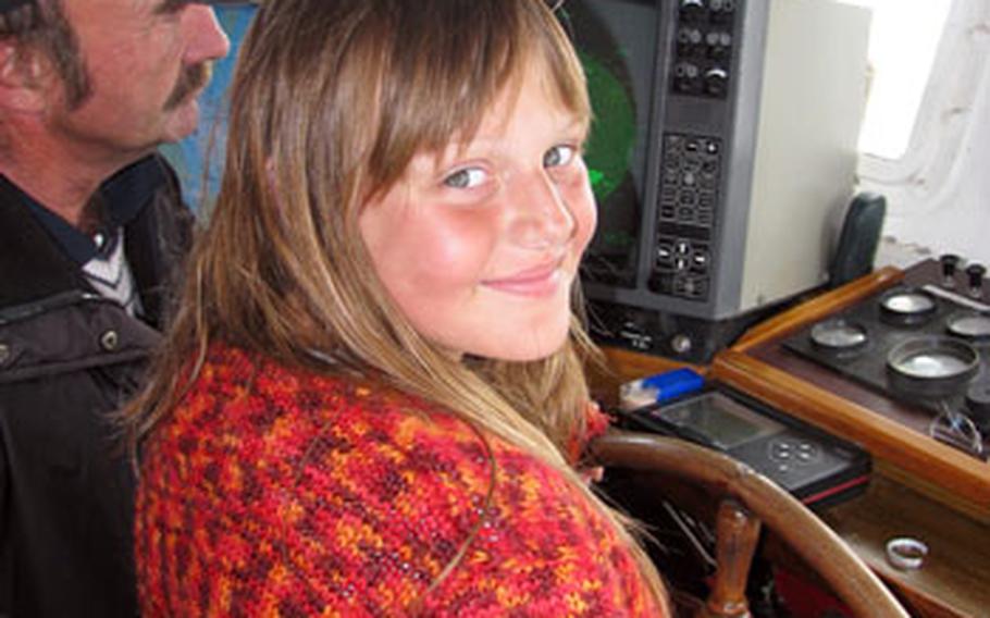 Peiper Murphy, from Heidelberg, Germany, takes a turn at the wheel of a North Sea fishing boat during a weeklong Camp A.R.M.Y. Island Adventure camp designed for children of deployed servicemembers in Europe.